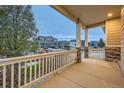 Covered porch with white railing, stone accents, and a view of the neighborhood at 2420 Nicholson St, Berthoud, CO 80513