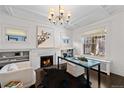 Bright home office featuring a fireplace, chandelier, built-in shelving, and large windows at 637 N Franklin St, Denver, CO 80218