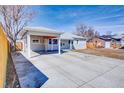 Charming one-story home featuring a large driveway and attached carport, perfect for parking and protection from the elements at 1589 S Mabry Way, Denver, CO 80219