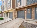 Close-up of townhome exteriors with stone accents, garages, and welcoming entryways showcasing detailed design at 2578 E Nichols Cir, Centennial, CO 80122