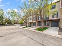 Attractive townhomes with attached garages on a tree-lined street, enhanced by well-maintained landscaping at 2578 E Nichols Cir, Centennial, CO 80122