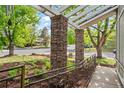 Charming front porch with stone pillars, pergola detail, metal railing, and landscaped surroundings at 2090 S Fairplay St, Aurora, CO 80014