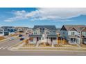Charming two-story home with a covered front porch, a well manicured lawn, and an attractive red door at 21821 E 7Th Ave, Aurora, CO 80018