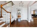 Lovely staircase and foyer features a wooden staircase, hardwood floors, and a modern chandelier at 30 Eudora St, Denver, CO 80220