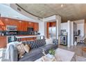 Stylish living room with open kitchen featuring stainless steel appliances and concrete ceiling at 1700 Bassett St # 412, Denver, CO 80202