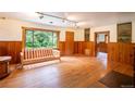 Bright living room with hardwood floors, wood paneling, and a large window overlooking nature at 35106 Boulder Canyon Dr, Boulder, CO 80302