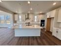 A modern kitchen with stainless steel appliances, white cabinets, and a spacious island with quartz countertops at 245 Wooten Ave, Brighton, CO 80601