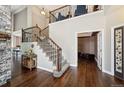 Grand foyer featuring hardwood floors, a stone accent wall, staircase, and an open view to the upper level at 5368 Wildcat Ct, Morrison, CO 80465