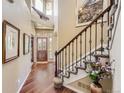 Grand foyer showcasing a beautiful staircase, hardwood floors, and stylish decor at 6435 Spotted Fawn Run, Littleton, CO 80125
