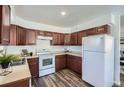 Functional kitchen equipped with white appliances, wooden cabinets, and durable flooring at 2060 W Iliff Ave, Englewood, CO 80110