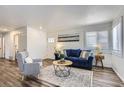 Inviting living room with wood floors, blue sofa, decorative rug, and an abundance of natural light at 2060 W Iliff Ave, Englewood, CO 80110