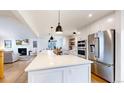 Modern white kitchen with large island, stainless steel appliances, and ample counter space at 6495 S Wright St, Littleton, CO 80127