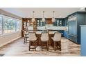 Modern kitchen with custom cabinets, a large island, pendant lighting, and stainless-steel appliances at 4505 S Yosemite St # 102, Denver, CO 80237