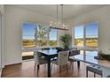 Elegant dining room with scenic views and stylish lighting fixture at 7572 Kelty Trl, Franktown, CO 80116