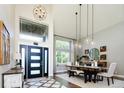 Grand entryway with soaring ceilings, stylish lighting, and modern front door, creating a welcoming first impression at 6787 Serena Ave, Castle Pines, CO 80108