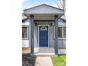 Inviting front porch with a stylish blue door and contemporary lighting fixtures at 3065 S Eudora St, Denver, CO 80222