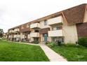 Two-story apartment with landscaped lawn and individual balconies for each apartment unit at 10211 Ura Ln # 9-308, Thornton, CO 80260