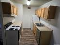 Cozy kitchen featuring a white range, stainless steel sink, refrigerator, and wood cabinets at 10211 Ura Ln # 9-308, Thornton, CO 80260