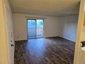 Bright living room with sliding doors to balcony, wood-look floors, and neutral walls at 10211 Ura Ln # 9-308, Thornton, CO 80260