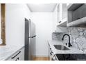 The updated kitchen features stainless appliances, white cabinets, and granite countertop at 3035 Oneal Pkwy # 20V, Boulder, CO 80301