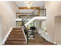 Grand foyer with a staircase, hardwood floors, a striking chandelier, and an open view to the living area at 7703 S Grape Ct, Centennial, CO 80122