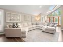 Bright living room showcasing a large sectional sofa, skylight, vaulted ceilings, and French doors at 7703 S Grape Ct, Centennial, CO 80122
