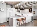 Modern kitchen with white countertops, stainless steel appliances, and adjacent seating area at 1610 Little Raven St # 302, Denver, CO 80202