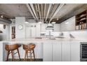 Stylish kitchen boasts white countertops, stainless steel appliances, and modern bar stool seating at 1610 Little Raven St # 302, Denver, CO 80202