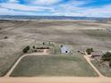 Expansive aerial view of a ranch featuring the house, barn, and land surrounded by picturesque mountains at 12973 Mesa View Rd, Larkspur, CO 80118