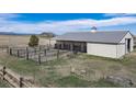 Large barn with stalls and fencing, perfect for horses or livestock on a sprawling ranch property at 12973 Mesa View Rd, Larkspur, CO 80118