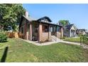 Well-maintained home showcasing a lush green lawn, mature trees, and classic architectural details at 3529 N Garfield St, Denver, CO 80205