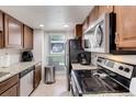 Galley kitchen boasts stainless appliances, granite countertops, and natural light at 3550 S Harlan St # 249, Denver, CO 80235