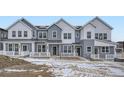 Three-unit townhome building, gray siding, white trim, and front porches at 14556 W 91St Ave # D, Arvada, CO 80005