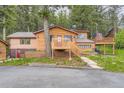 Charming log cabin with spacious deck surrounded by lush greenery and a beautifully landscaped yard at 8758 S Murphy Gulch Rd, Littleton, CO 80127