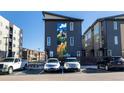 The exterior of this townhome features a mountain mural and ample parking at 5227 N Eliot St, Denver, CO 80221