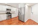 Bright kitchen featuring stainless steel appliances, white cabinets, granite countertops, and hardwood floors at 1461 S Danube Way # 104, Aurora, CO 80017