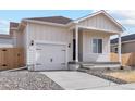 Well-lit front exterior featuring a driveway, garage, and a beautifully designed facade at 5863 Sawdust Dr, Brighton, CO 80601