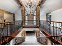 Grand interior balcony with stone columns and wrought iron railing overlooking living area at 12570 W 60Th Ave, Arvada, CO 80004