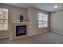 Cozy living room with a tiled fireplace, neutral carpet, and lots of natural light at 1425 Blue Sky Cir # 15-107, Erie, CO 80516