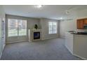 Bright open floorplan featuring a fireplace and breakfast bar with granite countertops at 1425 Blue Sky Cir # 15-107, Erie, CO 80516
