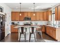 Bright kitchen with granite countertops, center island, stainless steel appliances and wood cabinetry at 5352 Truckee St, Denver, CO 80249