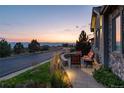 A peaceful view of a landscaped patio overlooking a scenic sunset and distant mountains, perfect for relaxing outdoors at 10877 Skydance Dr, Highlands Ranch, CO 80126
