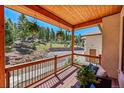 Covered porch with wooden railings, offering mountain views at 11626 Conifer Ridge Dr, Conifer, CO 80433