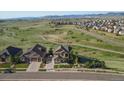 Aerial view of a home surrounded by lush greenery, complemented by mountain views at 17102 W 85Th Pl, Arvada, CO 80007
