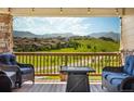 A scenic view of rolling hills from a cozy deck setting, featuring comfortable seating and a warm ambiance at 17102 W 85Th Pl, Arvada, CO 80007