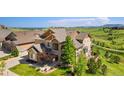 Stunning aerial view of a home with beautiful landscaping, a stone facade, and a well-maintained lawn at 17102 W 85Th Pl, Arvada, CO 80007