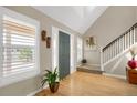 Bright foyer with hardwood floors, plantation shutters, a vaulted ceiling, and a staircase leading to the upper level at 1465 Arabian Trl, Elizabeth, CO 80107