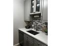 Kitchen featuring gray cabinets, mosaic backsplash, and marble countertops at 855 N Pennsylvania # 207, Denver, CO 80218