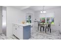 Eat-in kitchen boasts marble tile floors, white cabinets, peninsula island, and backyard views at 3274 S Heather Gardens Way, Aurora, CO 80014