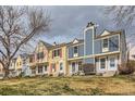 Street view showcasing colorful townhomes with well-maintained lawns and a cloudy sky at 9467 W Ontario Dr, Littleton, CO 80128
